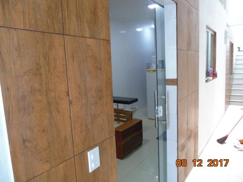 a glass door in a room with a wooden wall at Propriedade Silva in Gamboa