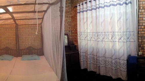 a bedroom with a canopy bed and a window at Hikka Urban Stay in Hikkaduwa