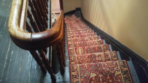 an escalator with a bunch of rugs on the stairs at The Harlem Flophouse in New York