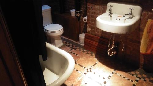 a bathroom with a sink and a tub and a toilet at The Harlem Flophouse in New York