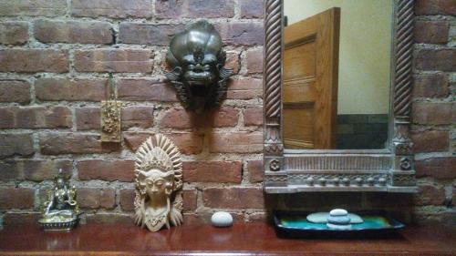 a brick wall with a mirror and some statues at The Harlem Flophouse in New York