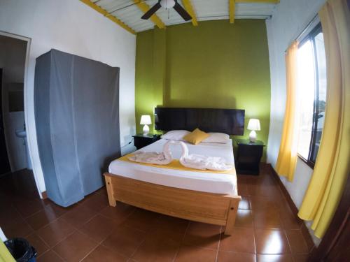 a bedroom with a bed with a green wall at Casa Brenes in Matagalpa