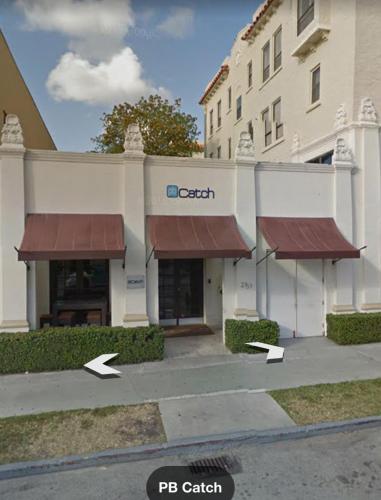 a building with two awnings in front of a hospital at TROPICAL Palm Beach WIFI 2BEDROOM 2BATHROOM OutdoorPOOL Beach Garden in Palm Beach