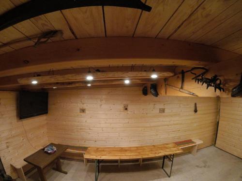a room with a stage with a wooden bench and a table at Tiroler Hasenhöhle in Wenns