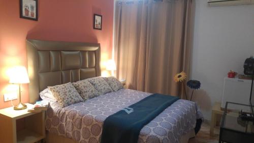 1 dormitorio con 1 cama y 1 mesa con lámpara en Hospederia V Centenario, en Estepona