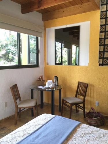 a room with a table and two chairs and a mirror at Refugio en el bosque de agua en Cuernavaca in Cuernavaca