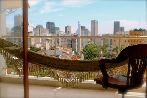 a hammock on a balcony with a view of a city at Casa da Gente in Rio de Janeiro