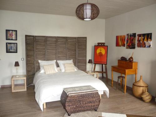 ein Schlafzimmer mit einem großen weißen Bett und einem Tisch in der Unterkunft Maison d'hôtes Cap Ouest in Le Guilvinec
