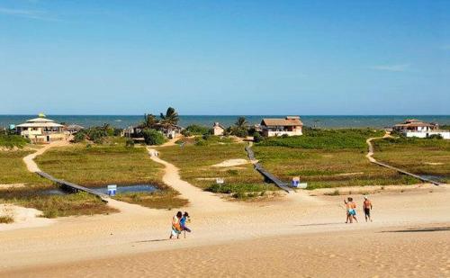 a group of people walking on a beach at Pousada Maia in Itaúnas