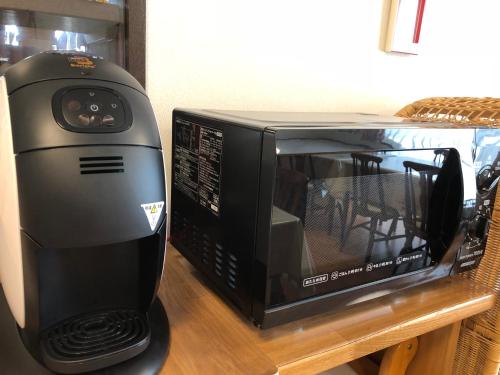 a black microwave sitting on top of a table at Yabukiso in Yamanakako