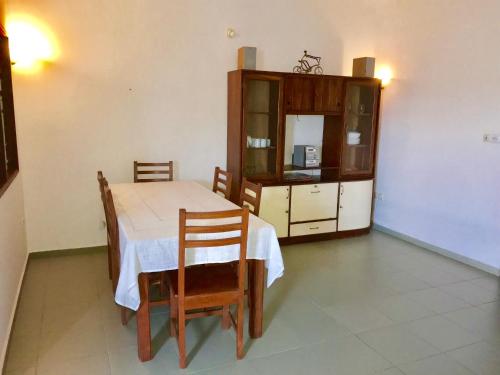 a dining room with a table and chairs and a cabinet at Dodoo Lodge in Cotonou