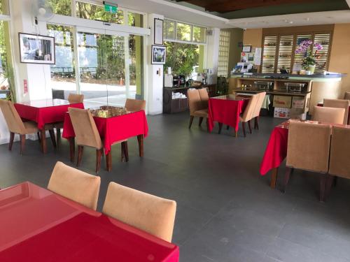 a dining room with red tables and chairs at Sunnydale B&B in Ren'ai