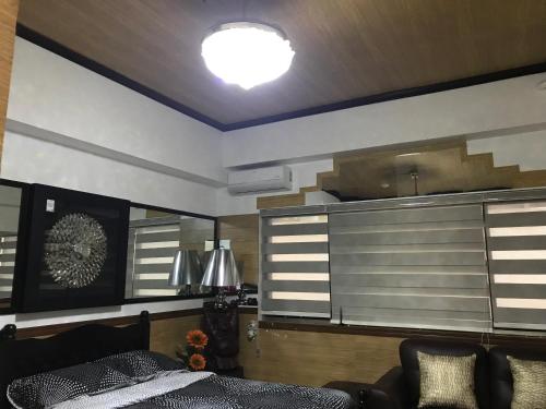 a living room with a bed and a kitchen at Condotel in Baguio