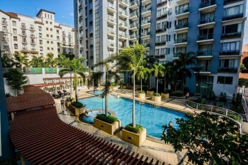 une grande piscine dans une ville avec de grands bâtiments dans l'établissement Norico's 1Bedroom @ One Palmtree Villas, à Manille