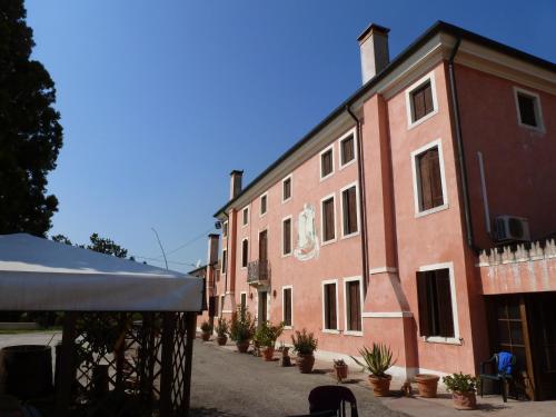 a large brick building with potted plants in front of it at Bordeghina B&B In Farmhouse in Pontecchio Polesine