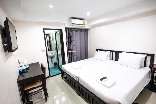 a bedroom with a bed and a table and a mirror at Don Muang Hotel in Bangkok