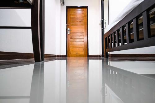 a hallway with a door and a shiny floor at Don Muang Hotel in Bangkok