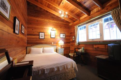 1 dormitorio con 1 cama en una cabaña de madera en Cingjing Hanging Garden & Resort en Renai
