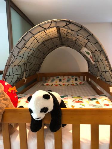 a stuffed cow toy is laying on a bed at CK cottage @ Khao Yai in Pak Chong