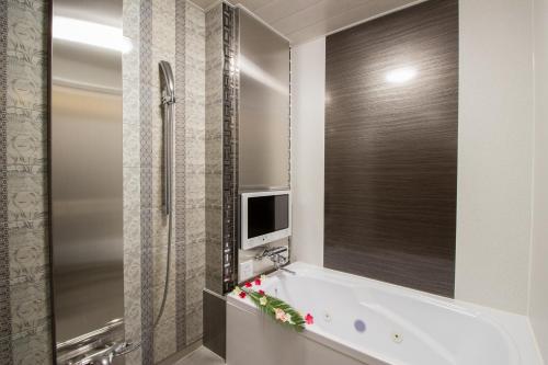 a bathroom with a tub with a tv and a mirror at ホテル アンジュエトワール 堺 - Adult Only in Sakai