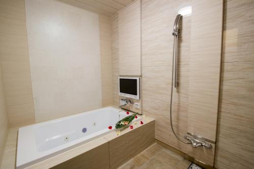 a bathroom with a tub and a shower with a tv at ホテル アンジュエトワール 堺 - Adult Only in Sakai