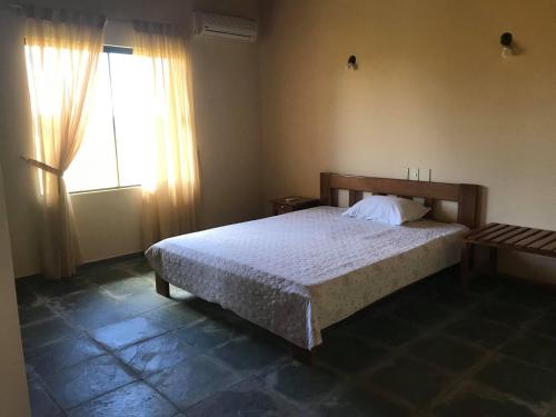 a bedroom with a large bed and a window at Carlos Franco Country Golf in Arroyos y Esteros
