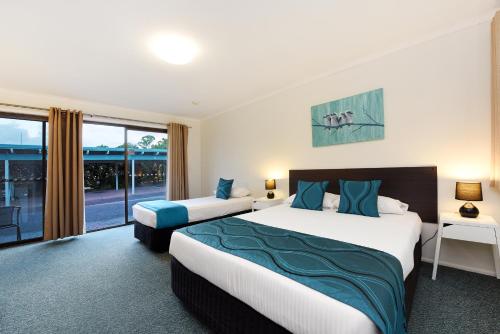 a hotel room with two beds and a large window at Motel in Nambour in Nambour