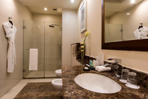 a bathroom with a sink and a shower at Concorde Hotel Doha in Doha