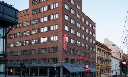 a tall brick building with a red sign on it at Thon Hotel Europa in Oslo