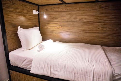 a bed in a room with a wooden wall at C 1 Colombo Fort in Colombo