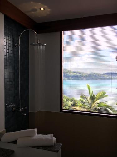 a bathroom with a shower and a large window at VILLA KIKI Seychelles in Anse a La Mouche
