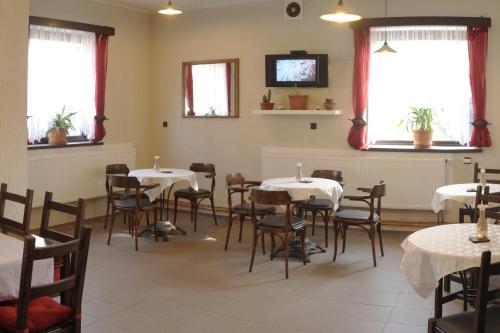 a dining room with tables and chairs and windows at Penzion "U Nádraží" in Horšovský Týn