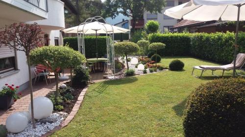 un giardino con gazebo, panchina e ombrellone di Ferienwohnung Guth a Wehr