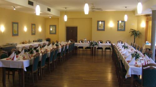 um salão de banquetes com mesas e cadeiras com toalhas de mesa brancas em Hotel YORK em Plzeň