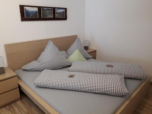 een slaapkamer met 2 bedden en geruite kussens bij Apart Alpenflair in Sankt Leonhard im Pitztal