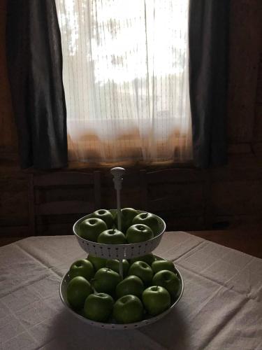 a bowl of green apples sitting on top of a table at Manka Kisrönkház in Ispánk
