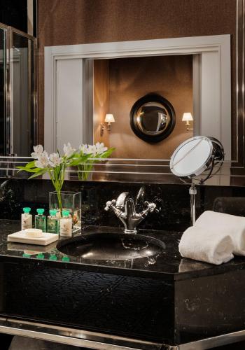 a bathroom with a sink and a mirror at Hotel Rector in Salamanca