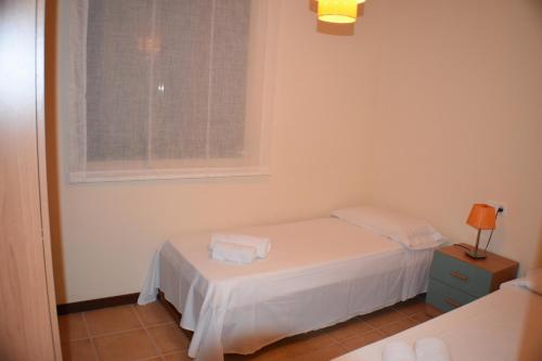 アンポスタにあるApartament Montserrat Eucaliptus 3の小さなベッドルーム(ベッド1台、窓付)