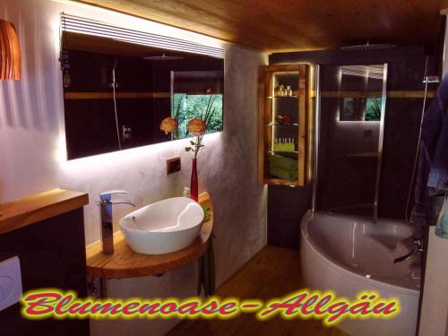 ein Badezimmer mit einem Waschbecken, einem WC und einer Badewanne in der Unterkunft Blumenoase Allgäu in Schwanden