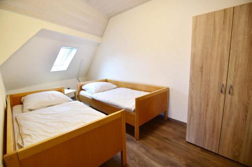 a small room with two beds and a cabinet at Work & Stay Ferienhaus Niederkassel in Rheidt