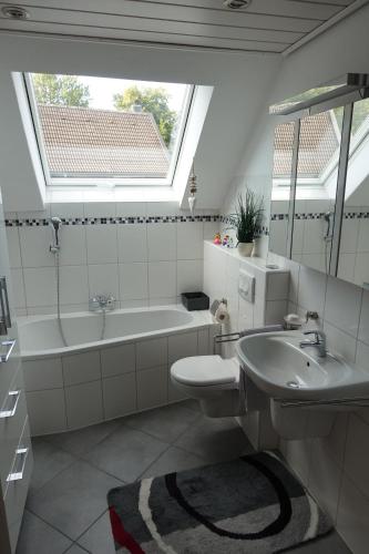 a bathroom with a sink and a tub and a mirror at Ferienwohnung Lindlar-Linde in Lindlar