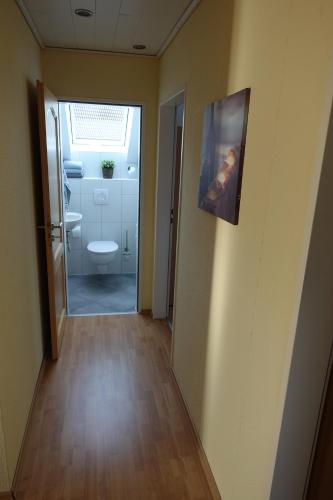 a hallway of a bathroom with a toilet and a window at Ferienwohnung Lindlar-Linde in Lindlar