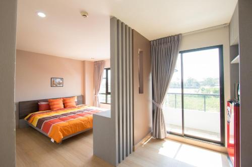 een slaapkamer met een bed en een groot raam bij Live at Home Sukhumvit 105 in Bangkok