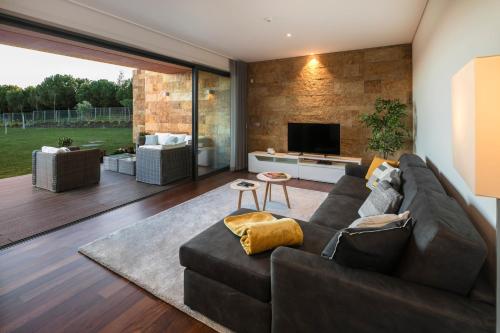 a living room with a couch and a television at L Orangerie CA by Intiholidays in Vilamoura