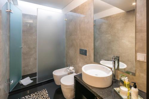 a bathroom with a sink and a toilet and a mirror at L Orangerie CA by Intiholidays in Vilamoura