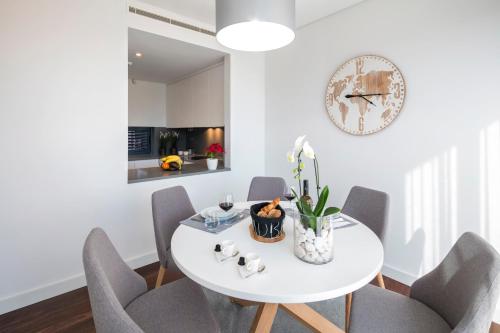 a white dining room with a white table and chairs at L Orangerie CA by Intiholidays in Vilamoura