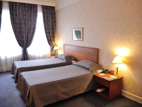 a hotel room with two beds and a table at Grand Hotel Ukraine in Dnipro