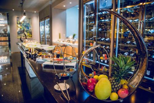 a bar with baskets of fruit on a counter at Cachet Boutique Kunming Artime in Kunming