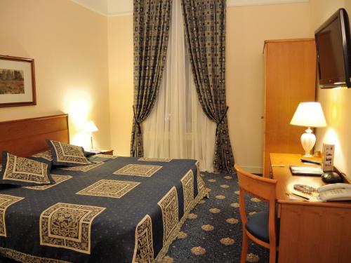 a hotel room with a bed and a desk at Grand Hotel Ukraine in Dnipro