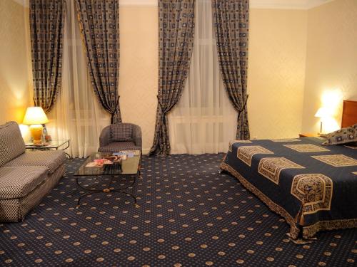 a hotel room with a bed and a couch at Grand Hotel Ukraine in Dnipro